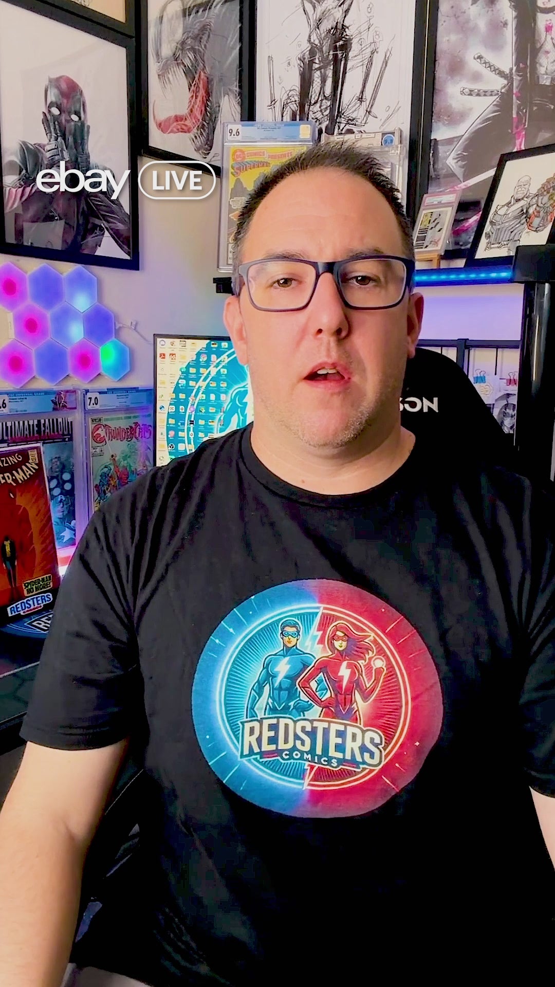 Load video: Behind-the-scenes video of Liam at Redsters Comics livestreaming and packing customer comic orders.